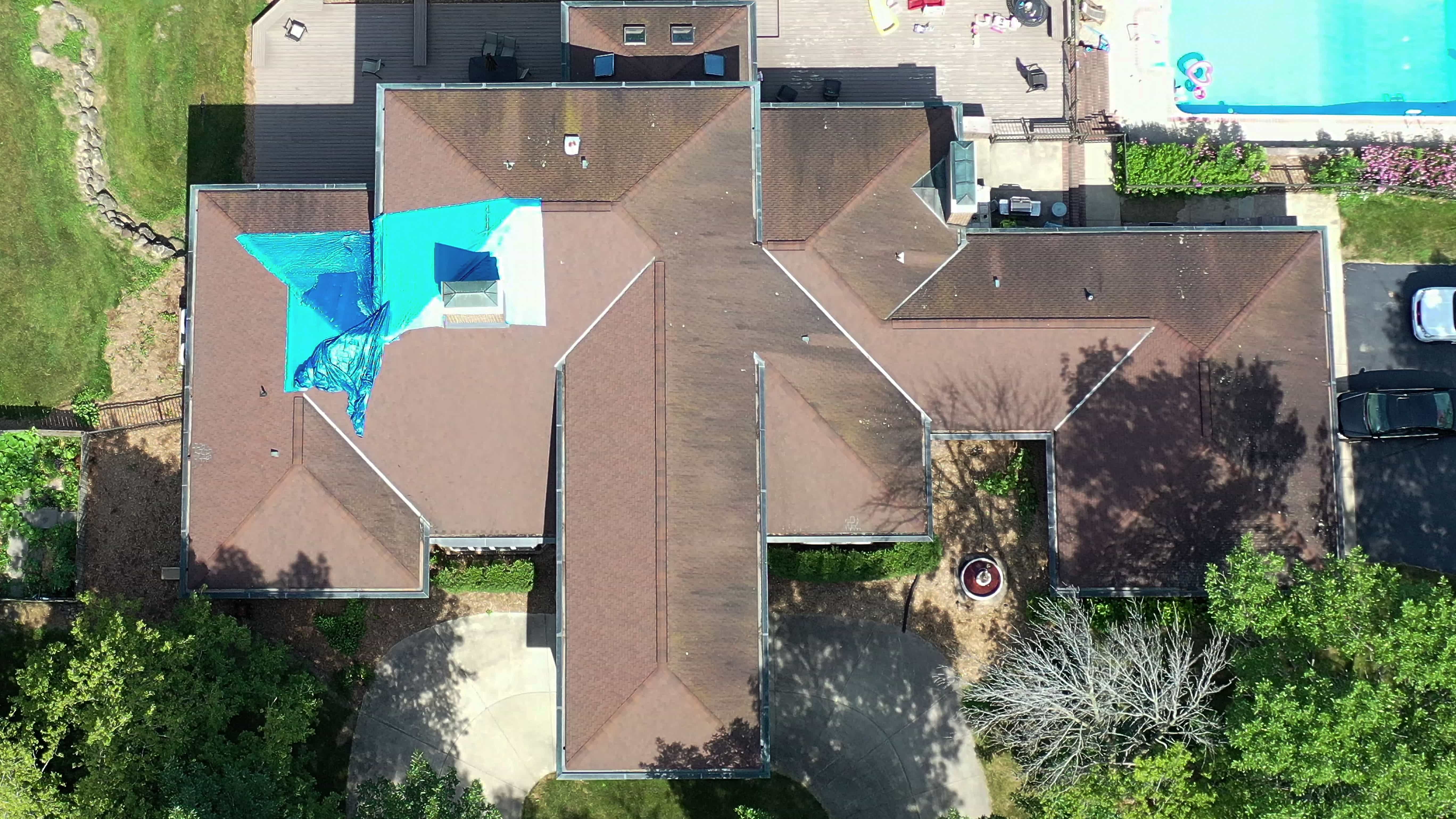 Before of a roofer project with a tarp on the roof. 