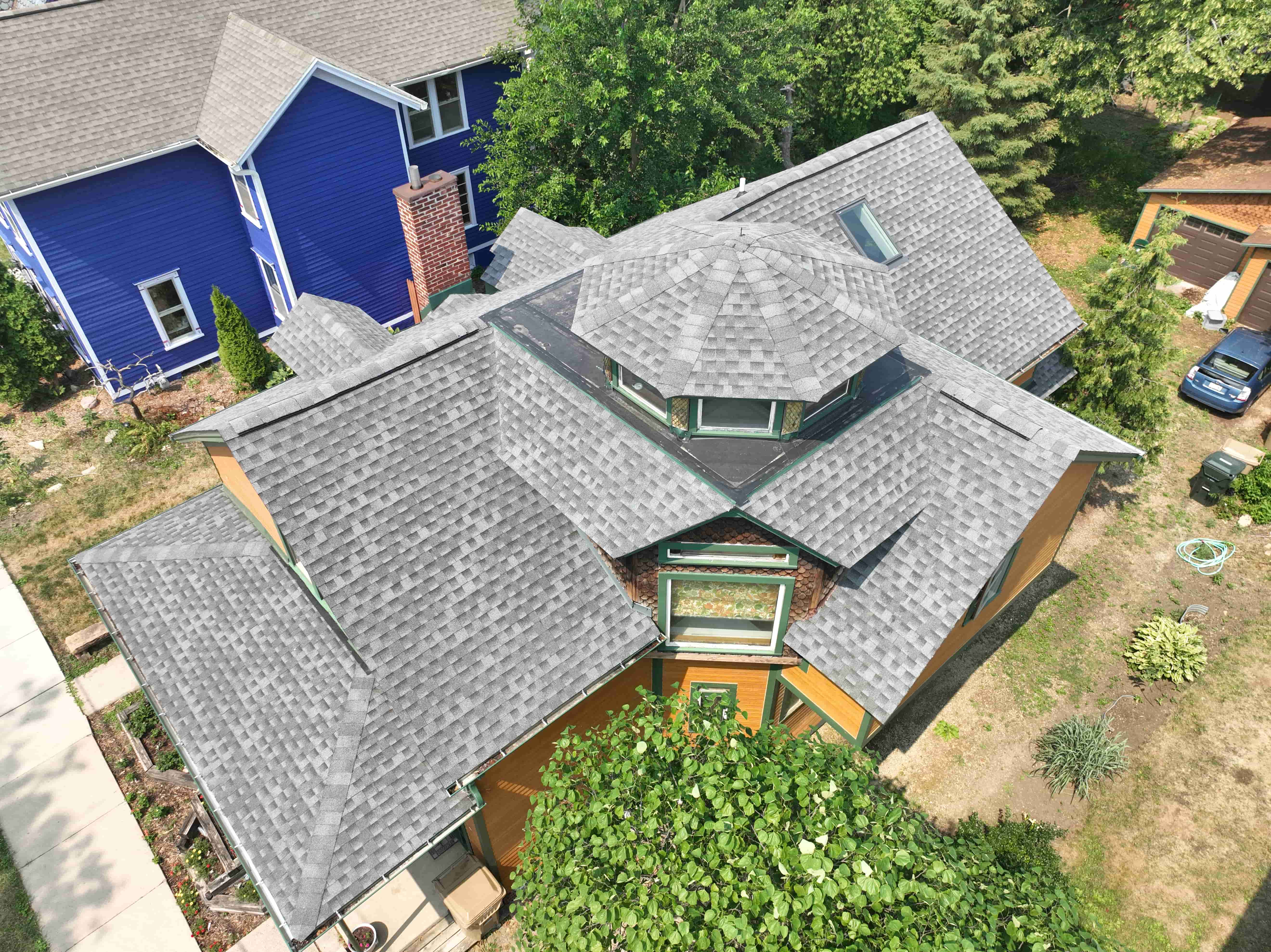 Aerial view of complex roof structure highlighting detailed shingle installation and precise alignment on multiple angles