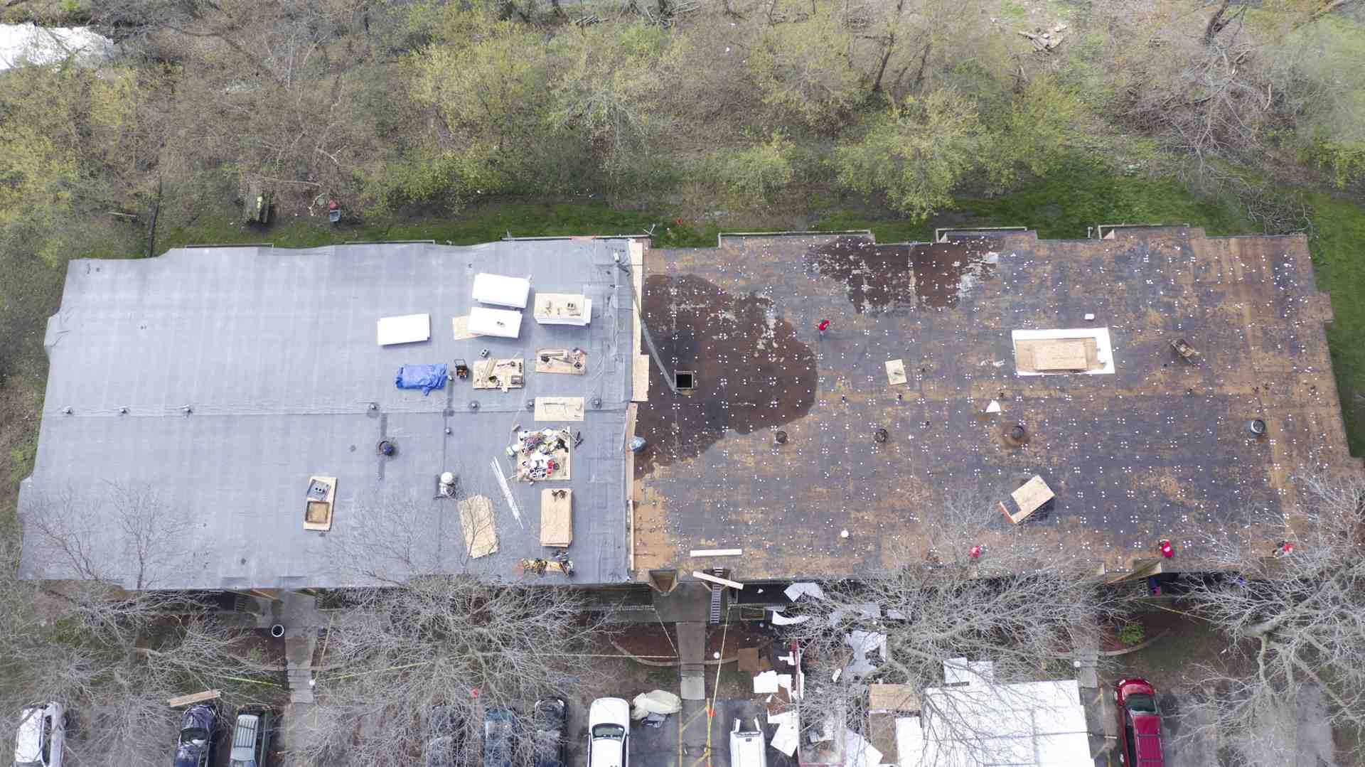 Roofing crew safely removing old shingles from an Appleton home - Cost of tear off and new asphalt roof Appleton